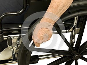 Older hand on wheel chair