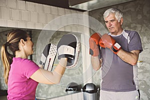 Older man boxing in gym.