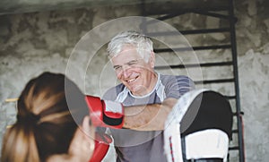 Older man boxing in gym.