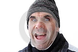 An older man with cap makes a surprised-joyful face