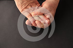 Older man grips his numb fingers photo