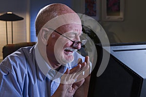 Older man grossed out with content on his computer, horizontal