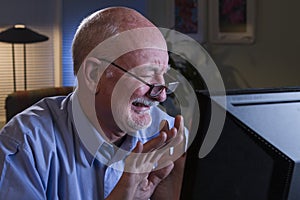 Older man grossed out with content on his computer, horizontal photo