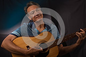 Older Man having fun playing his acoustic guitar