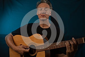 Older Man having fun playing his acoustic guitar