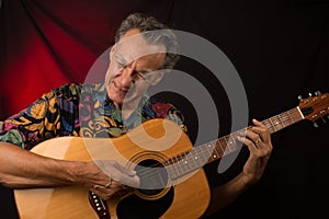 Older Man having fun playing his acoustic guitar