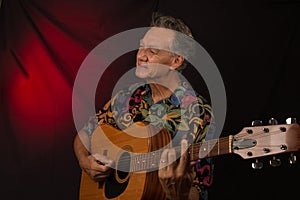 Older Man having fun playing his acoustic guitar