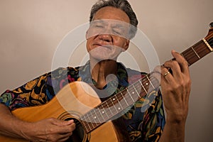 Older Man having fun playing his acoustic guitar