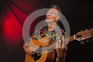 Older Man having fun playing his acoustic guitar