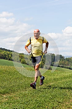 Older man jogging running on meadow