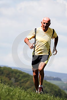 Older man jogging running on meadow