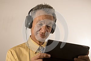 Older man listening to music on his smart tablet