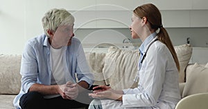 Older man listens to female doctor during visit