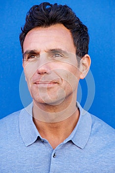 Older man looking away against blue background