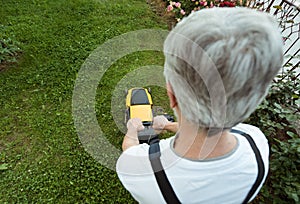 Older man mowing the lawn