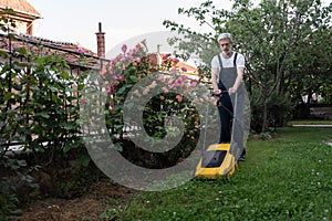 Older man mowing the lawn