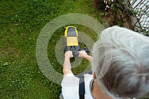 Older man mowing the lawn