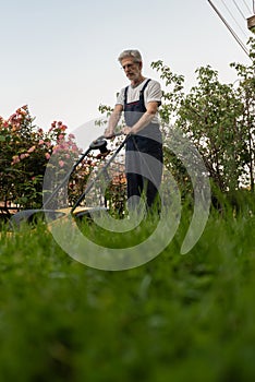 Older man mowing the lawn