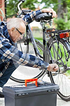 Older man repairing a bicycle