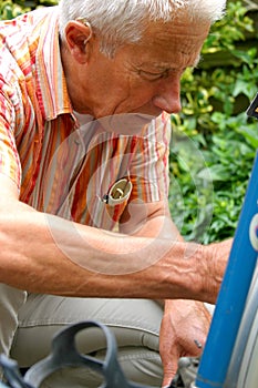 Older man repairing his bike