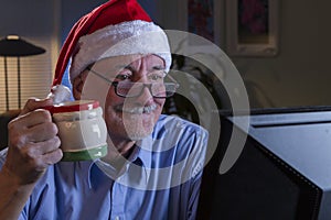 Older man in Santa hat looking happy and nostalgic, horizontal