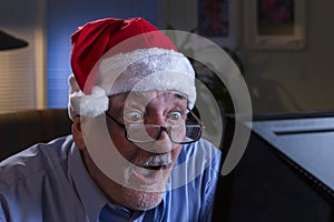 Older man in Santa hat looking shocked, horizontal