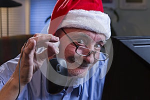 Older man in Santa hat shopping online, horizontal