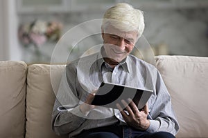 Older man spends leisure use digital tablet