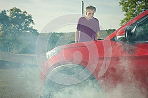 Older man on trip desperate od his car with smoking engine and breakdown