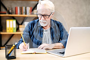 Older man using laptop for studying, working