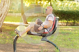 Older man working out on the sports public equipment in the outdoor gym.