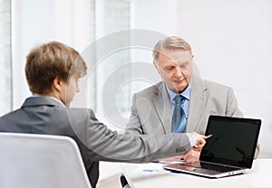 Older man and young man with laptop computer