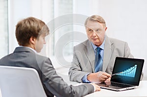 Older man and young man with laptop computer