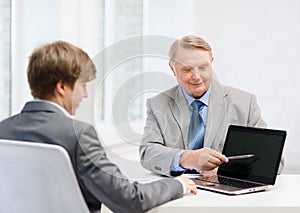 Older man and young man with laptop computer