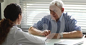 Older patient signing health insurance agreement in clinic