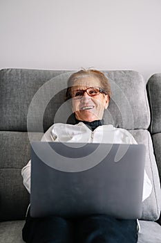 granmother using computer to conference with family during confinement by covid