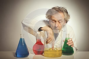 Older retro style chemist working with several dozes of chemicals