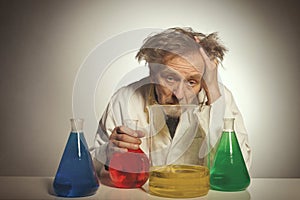 Older retro style chemist working with several dozes of chemicals