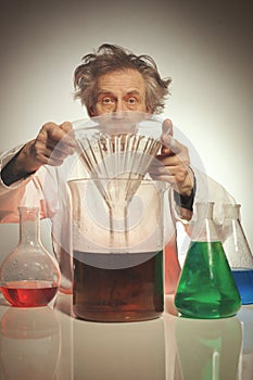 Older retro style chemist working with several dozes of chemicals