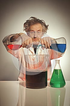 Older retro style chemist working with several dozes of chemicals