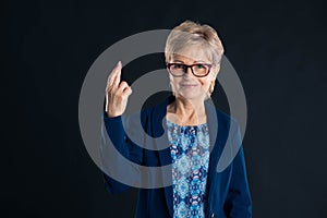 Older secretary showing good luck sign