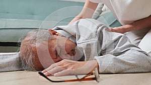 Older senior man headache lying on the floor after falling