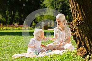 Older sister feeding a small brother with a cake