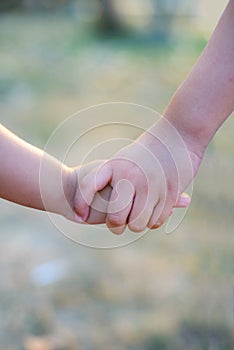 Older sister`s hand holding her brother`s hand together to take care.