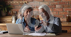 Older spouses discussing current month expenses, checking receipts of payment