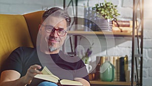 Older white man in glasses reading at home