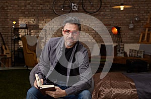 Older white man reading book at home