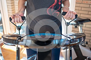 Older white woman doing exercises with her arms on a machine that vibrates to keep fit at home.