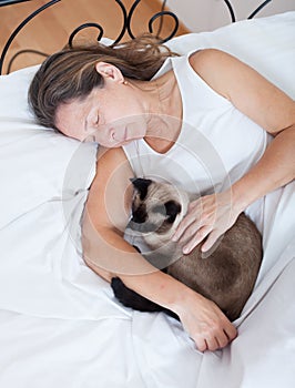 Older woman with cat sleeping