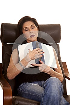 Older woman in chair with book asleep